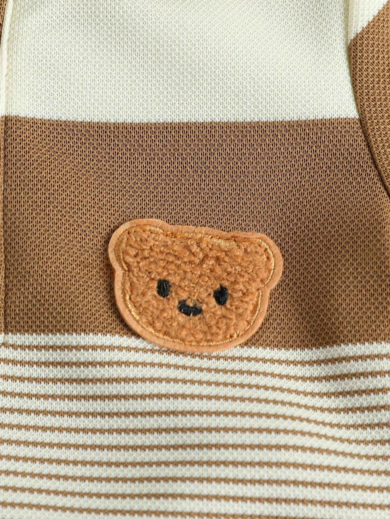 Ourson brodé sur le polo de l'ensemble bébé